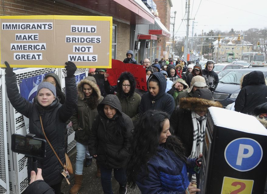 Several dozen area residents marched down Broadway Avenue in Pittsburgh's Beechview Ave. Thursday Feb. 16, 2017, protesting the recent crackdowns on immigrants ordered by President Donald Trump. "Day Without Immigrants" protests are being held across the United States. (Nate Guidry/Pittsburgh Post-Gazette via AP)