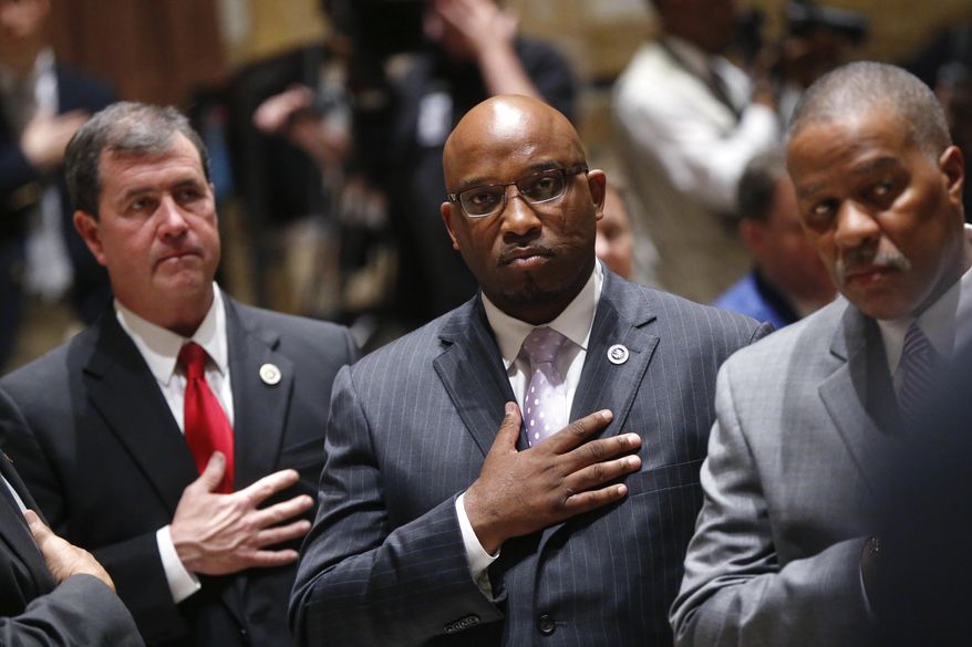 FILE - In this Feb. 13, 2017 file photo, Louisiana State Sen. Troy Brown, D-Geismar, center, holds his hand to his chest during the national anthem at the opening of a special session of the state legislature in Baton Rouge, La. Brown stepped down from his position Thursday, Feb. 16, a day after senators moved ahead with historic expulsion proceedings. Brown pleaded no contest twice over the past year to misdemeanor charges involving abuse against women. (AP Photo/Gerald Herbert, Pool, File)