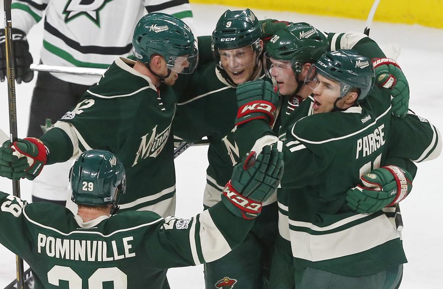 Minnesota Wild players celebrate a power-play goal by Ryan Suter, second from right, off Dallas Stars goalie Kari Lehtonen during the first period of an NHL hockey game Thursday, Feb. 16, 2017, in St. Paul, Minn. (AP Photo/Jim Mone)