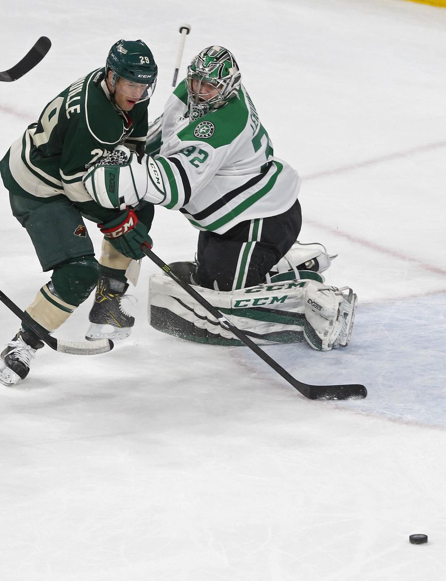Dallas Stars goalie Kari Lehtonen, right, of Finland, tries to keep Minnesota Wild&#x27;s Jason Pominville from chasing the puck during the second period of an NHL hockey game Thursday, Feb. 16, 2017, in St. Paul, Minn. (AP Photo/Jim Mone)