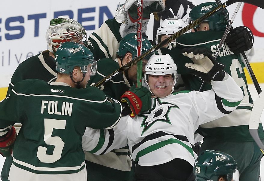 Dallas Stars&#x27; Antoine Roussel, right, of France, gets tangled up in a scrum including Minnesota Wild&#x27;s Christian Folin, left of Sweden, during the second period of an NHL hockey game Thursday, Feb. 16, 2017, in St. Paul, Minn. (AP Photo/Jim Mone)
