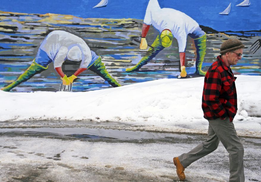 Clammers appear to be digging in snowpiles in artist Susan Bartlett Rice&#x27;s mural as Joe Downs of Portland, walks past in Portland, Me., Thursday, Feb. 16, 2017. (Ben McCanna/Portland Press Herald via AP)