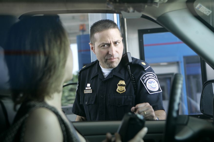 U.S. Customs and Border Protection officer Kevin Corsaro speaks with an unidentified motorist entering the United States from Canada at the border in Buffalo, N.Y., on June 6, 2006. (Associated Press) **FILE**