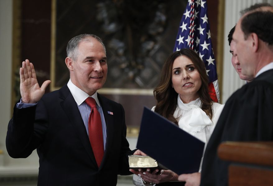 Supreme Court associate justice Samuel Alito, right, swears in Scott Pruitt as the Environmental Protection Agency Administrator in the Eisenhower Executive Office Building in the White House complex in Washington, Friday, Feb. 17, 2017. Holding the bible is Marlyn Pruitt, wife of Scott Pruitt, and their son Cade Pruitt is standing second from right. (AP Photo/Carolyn Kaster)