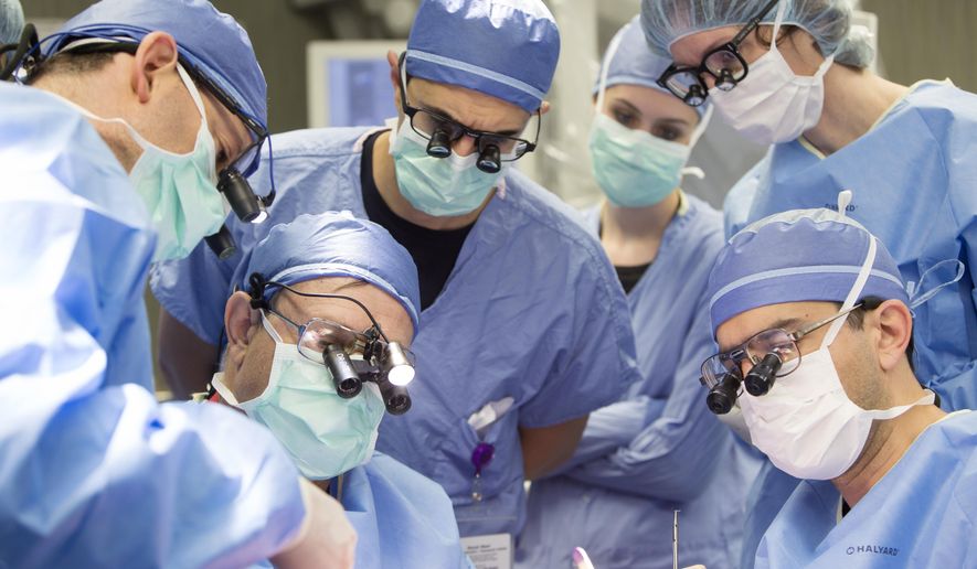 CORRECTS BYLINE TO JEANNA L. DUERSCHERL - In this June 13, 2016 photo provided by the Mayo Clinic, a medical team performs a face transplant surgery at the medical center in Rochester, Minn. It took about 24 hours to procure the donor's face, which involved taking bone, muscle, skin and nerves, and almost the same time to prepare the recipient. His entire face was rebuilt below his eyes, taking an additional 32 hours. The medical team rotated, taking four-hour breaks through the weekend. (Jeanna L. Duerscherl/Mayo Clinic via AP)