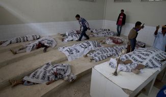 Dead bodies of alleged militants killed in a crackdown operation by security forces are laid at a mortuary in Karachi, Pakistan, Friday, Feb. 17, 2017. Pakistani security forces arrested dozens of suspects in sweeping raids a day after a massive bombing claimed by the Islamic State group killed dozens of worshippers at a famed Sufi shrine in a southern province. (AP Photo/Shakil Adil)