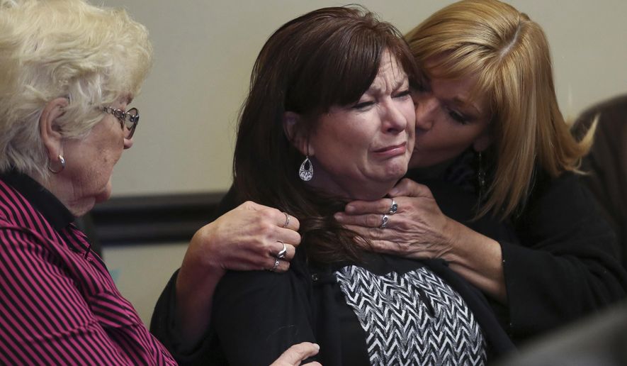 FILE - In this Jan. 23, 2015, file pool photo, Susan Hunt, center, shed tears while surrounded by family during a court appearance in Saratoga Springs, Utah. Hunt, whose son was shot by police while holding a costume samurai sword, has settled a lawsuit over his death, resolving a conflict with her onetime lawyer that reached a federal appeals court. (Spenser Heaps/The Daily Herald via AP, Pool, File)