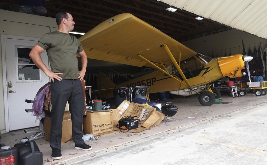 FILE - In this, Monday, Feb. 13, 2017, file photo, Jorge Gonzalez, of Skywords Advertising, is seen with his Piper Super Cub at the hangar he rents at Lantana Airport in Latana, Fla. Gonzalez said during a meeting with U.S. Rep. Lois Frankel that he might have to shutter his business if President Trump continues to visit Palm Beach and close the air space on weekends. (Joe Cavaretta/South Florida Sun-Sentinel via AP, File)
