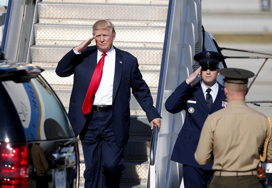 President Donald Trump salutes as he steps off of Air Force One as he arrives in West Palm Beach, Fla., Friday, Feb. 17, 2017. (AP Photo/Wilfredo Lee)
