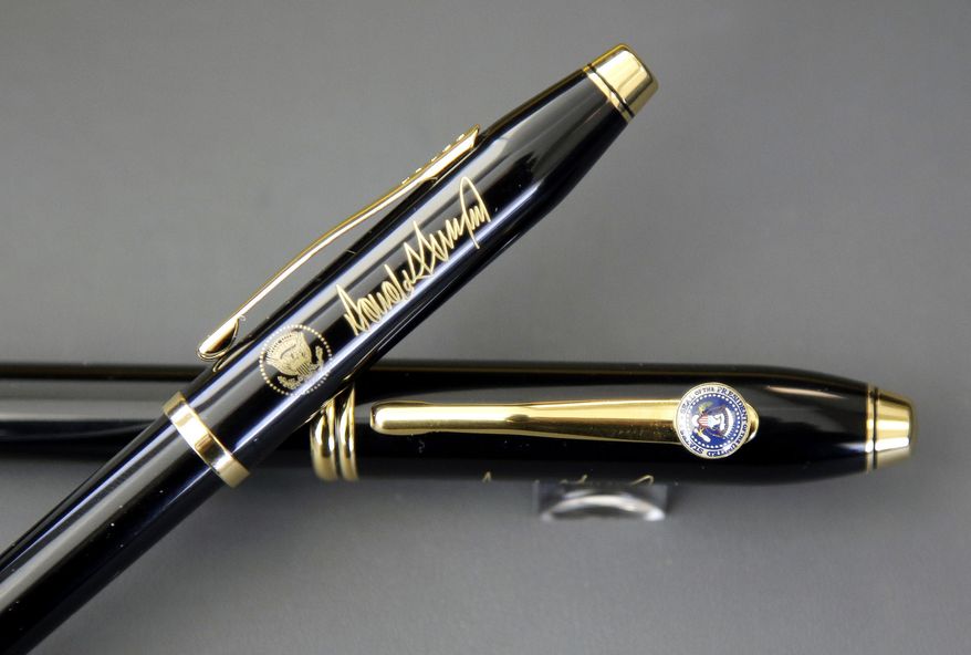 In this Tuesday, Feb. 14, 2017, photo A.T. Cross Co. custom-made pens, designed for President Donald Trump, featuring his signature and presidential seals, are displayed together at the Cross Company Store in Providence, R.I. Trump chose the Cross Century II model, top, for deliveries to the White House over the Cross Townsend model, below. (AP Photo/Steven Senne)