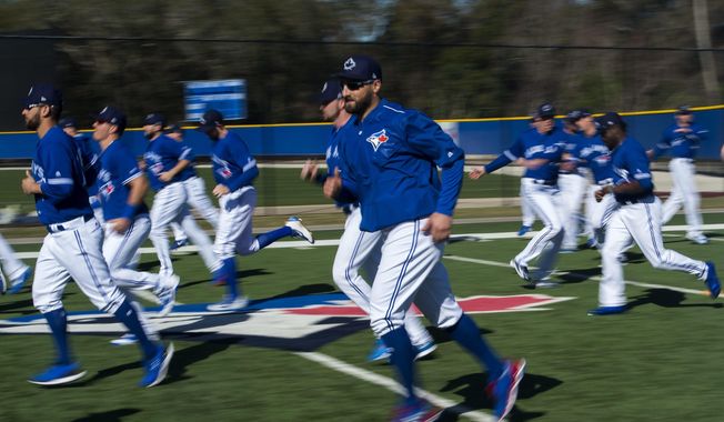 Toronto Blue Jays center fielder Kevin Pillar, center, warms up with his team during baseball spring training in Dunedin, Fla., on Friday, Feb. 17, 2017. (Nathan Denette/The Canadian Press via AP)