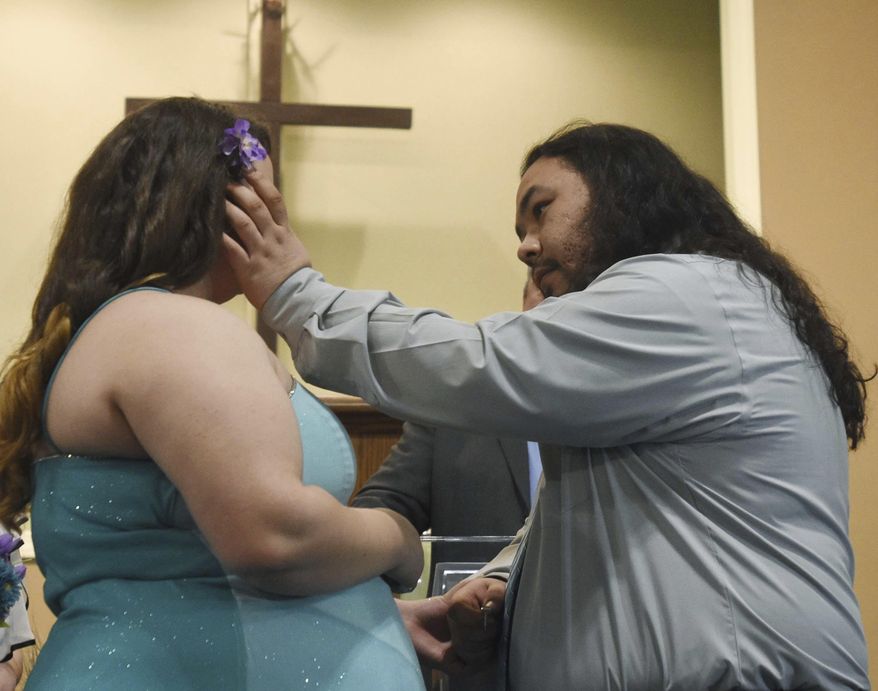 Tanner Weirich wipes a tear from the face of his bride, Jenna Mosher, during their wedding Tuesday, Feb. 14, 2017, at Heartland Christian Center in Vine Grove, Ky.(Jill Pickett/The News-Enterprise via AP)