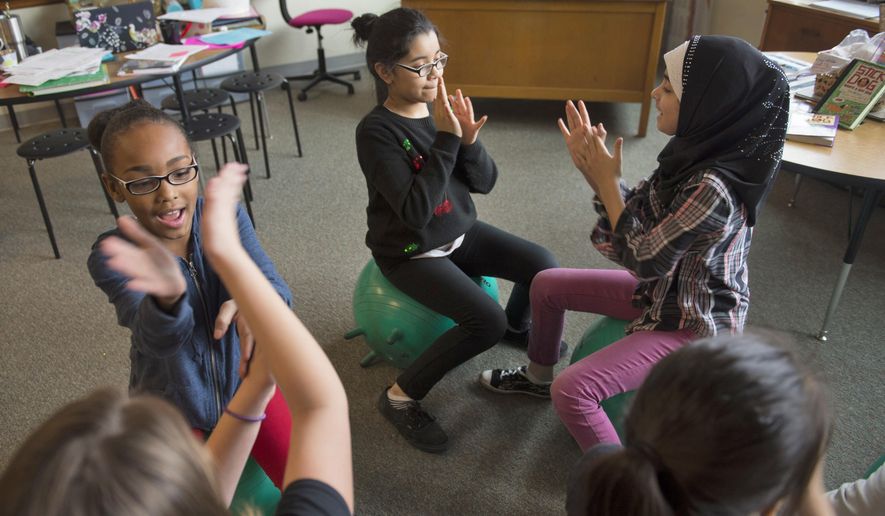 In this Friday, Jan. 13, 2017 photo, from left, Tashaiyah Dyer-Turner, Brooke Roldan and Fatma Al-Asady have fun during free time in Mackenzie Wylie's fourth grade class at Saratoga Elementary School. In the weeks Wylie's had stability balls in her classroom at Saratoga Elementary, she's noticed good things. Her fourth-graders, she said, are more focused on the task at hand. The balls are providing a way for students who have a hard time sitting still to work off excess energy. (Jake Crandall/The Journal-Star via AP)