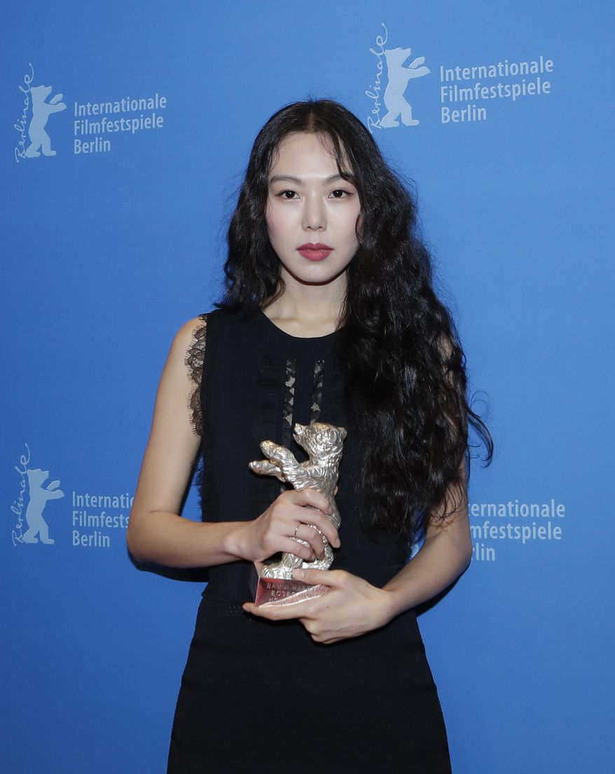 Actress Kim Minhee poses for photographers with the Silver Bear Best Actress Award for 'On The Beach at Night Alone' during the award ceremony at the 2017 Berlinale Film Festival in Berlin, Germany, Saturday, Feb. 18, 2017. (AP Photo/Markus Schreiber)