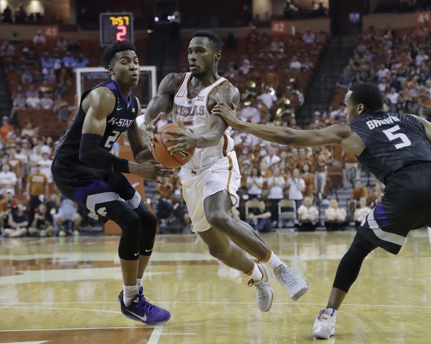 Texas guard Kendal Yancy (5) drives between Kansas State defenders Wesley Iwundu (25) and Barry Brown (5) during the second half of an NCAA college basketball game, Saturday, Feb. 18, 2017, in Austin, Texas. Kansas State won 64-61. (AP Photo/Eric Gay)