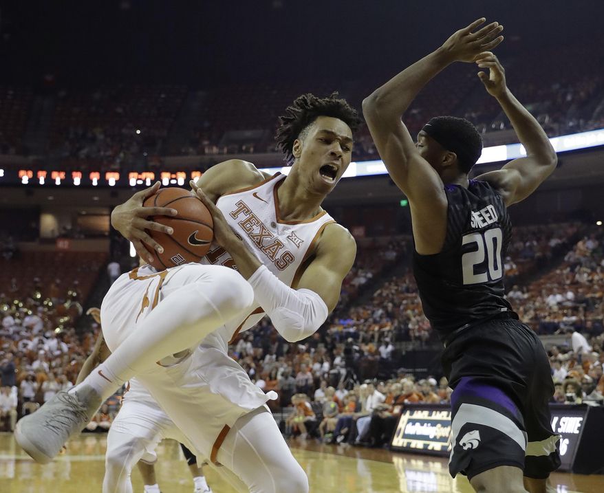 Texas forward Mareik Isom (14) grabs a rebound in front of Kansas State forward Xavier Sneed (20) during the first half of an NCAA college basketball game, Saturday, Feb. 18, 2017, in Austin, Texas. (AP Photo/Eric Gay)