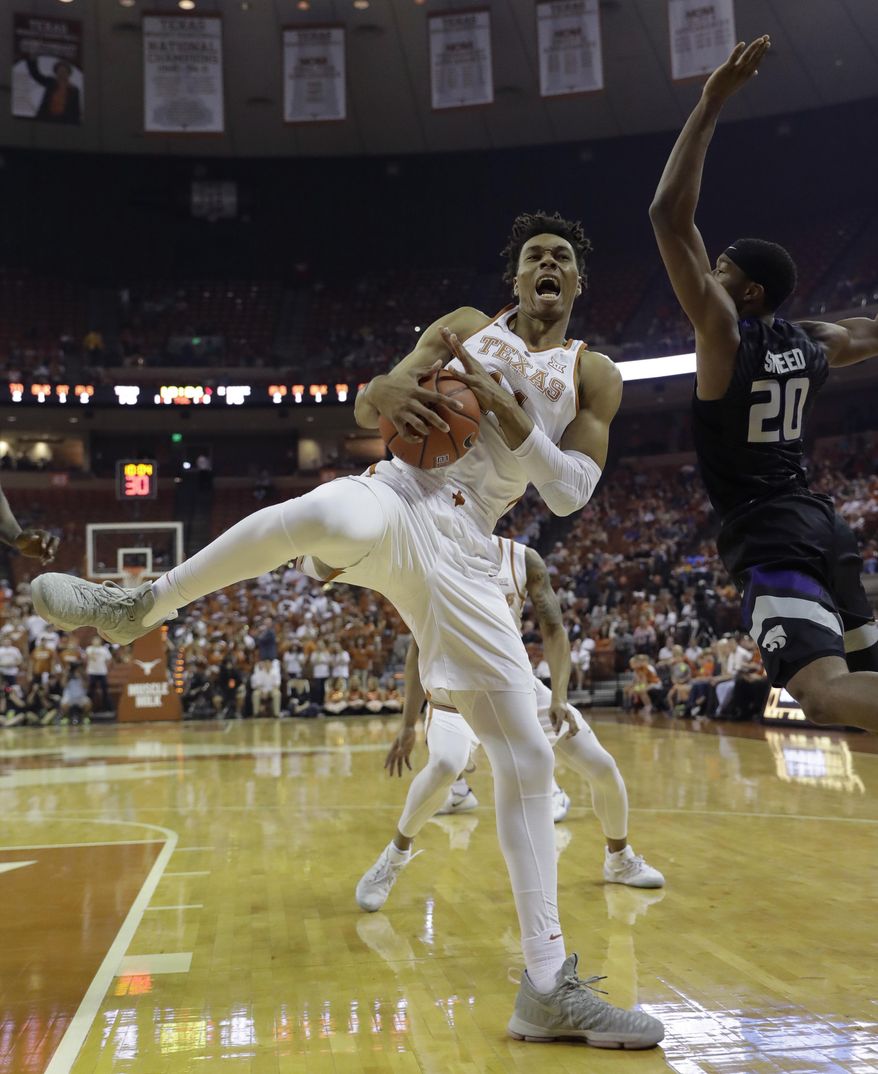 Texas forward Mareik Isom (14) grabs a rebound in front of Kansas State forward Xavier Sneed (20) during the first half of an NCAA college basketball game, Saturday, Feb. 18, 2017, in Austin, Texas. (AP Photo/Eric Gay)