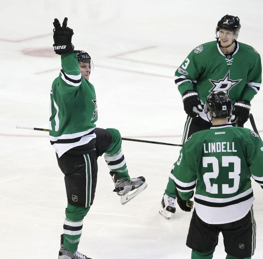 Dallas Stars left wing Antoine Roussel (21) celebrates scoring his third goal of the night with teammates Esa Lindell (23) and John Klingberg (3) during the third period of the Stars&#x27; NHL hockey game against the Tampa Bay Lightning in Dallas, Saturday, Feb. 18, 2017. The Stars won 4-3 in overtime. (AP Photo/LM Otero)