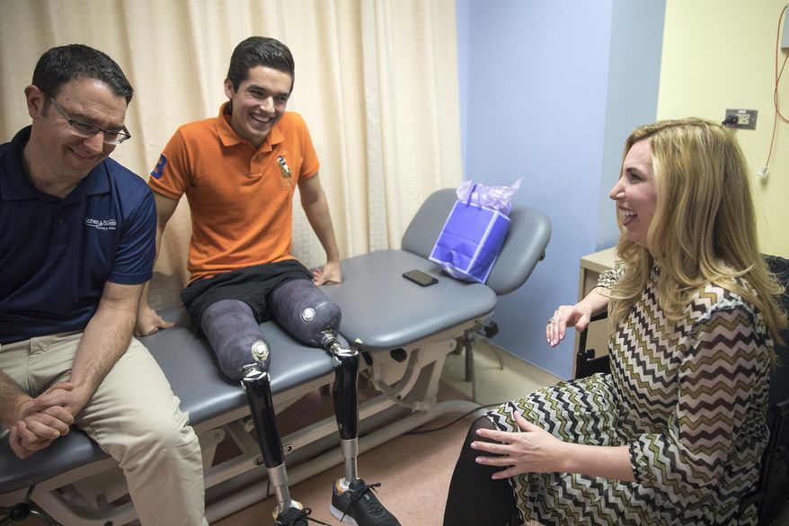 In this Monday, Feb. 13, 2017 photo, Heather Abbott, right, prosthetist David Rotter, left, and Vidal Lopez talk amongst themselves at the University of Illinois at Chicago Hospital, in the Near West Side neighborhood. Abbott, a survivor of the Boston Marathon bombing and founder of The Heather Abbott Foundation, teamed up with Scheck & Siress, a Chicago based prosthetic firm, to provide Lopez with new customizable prosthetic legs. Vidal was born in Chicago but grew up in Mexico. A car crash involving a tractor trailer in July 2016, left him without his legs. He wrote to the Heather Abbott Foundation with hopes to receive a grant to help him pay for the prosthetic legs that he needed. Heather was touched by his story and decided to provide Vidal with the financial support he needed to secure his future. (Alyssa Pointer/Chicago Tribune via AP)