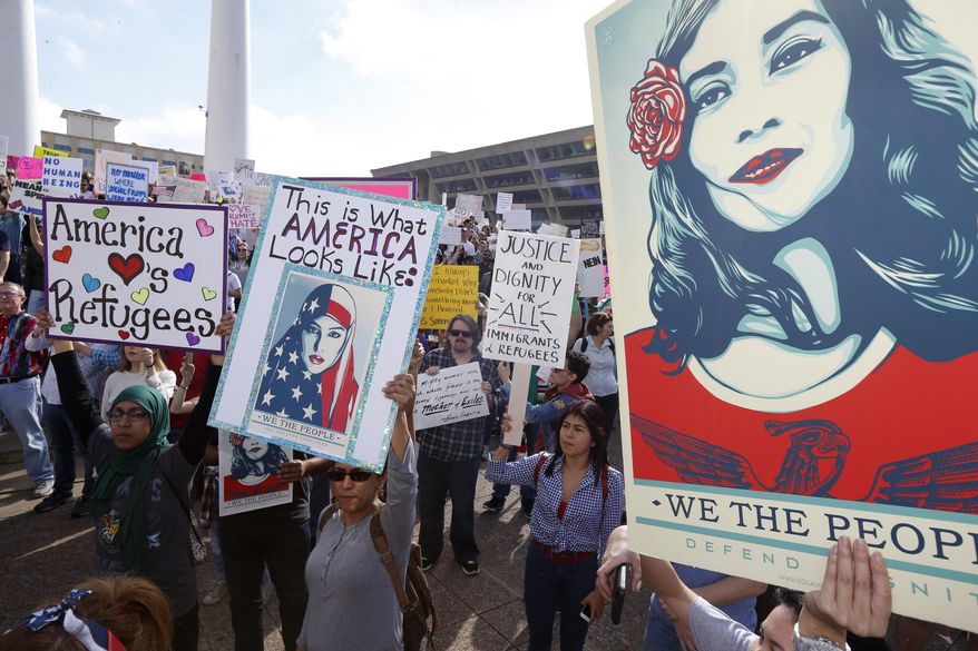 Protestors for immigrant and refugee communities in downtown in front of Dallas City Hall Saturday, Feb. 18, 2017. Over 1,500 people rallied in downtown Dallas in a peaceful show of support for immigrants and refugees, protesting President Donald Trump's immigration policies. (Nathan Hunsinger/The Dallas Morning News via AP)