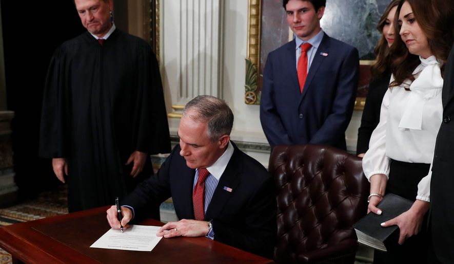Employees of the Environmental Protection Agency are publicly questioning new administrator Scott Pruitt&#39;s (seated) ties to the energy sector, worried that such links may affect his ability to do the job. (Associated Press)