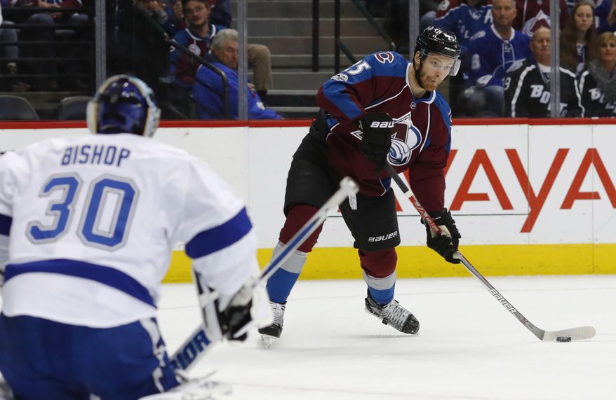Colorado Avalanche center Mikhail Grigorenko, back, of Russia, looks to shoot the puck at Tampa Bay Lightning goalie Ben Bishop in the first period of an NHL hockey game Sunday, Feb. 19, 2017, in Denver. (AP Photo/David Zalubowski)