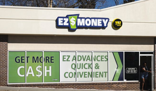 In this Friday, Feb. 17, 2017 photo, an unidentified person leaves the EZ Money Check Cashing storefront in Omaha, Neb. About 80 Nebraska businesses offer payday loans, according to the state Department of Banking and Finance. Several of these businesses, including EZ Money, have multiple storefronts. A Nebraska legislative committee on Tuesday, Feb. 21, 2017, will hear two vastly different approaches to regulating the payday lending industry. (AP Photo/Nati Harnik)
