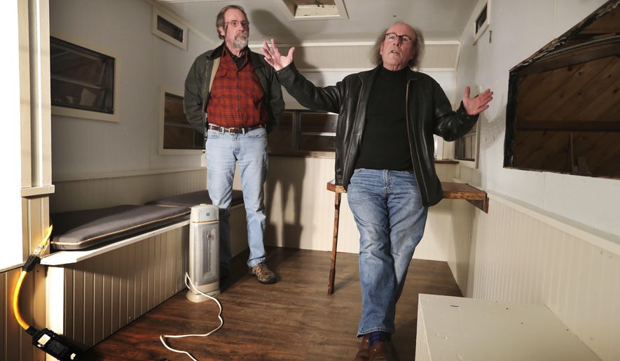 In this Tuesday, Feb. 7, 2017, photo, Tim Cheney, right, and Adrian Hooper, co-founders of Chooper's Guide, a comprehensive addiction treatment program, discuss plans for a trailer they are retrofitting in Walpole, Maine. The mobile unit will provide addiction treatment services to underserved parts of rural Maine. (AP Photo/Robert F. Bukaty)