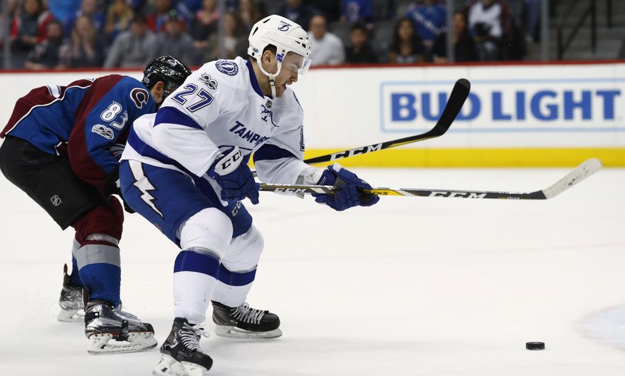 Tampa Bay Lightning left wing Jonathan Drouin, front, drives past Colorado Avalanche left wing Matt Nieto to score the winning goal in overtime of an NHL hockey game, Sunday, Feb. 19, 2017, in Denver. Tampa Bay won 3-2. (AP Photo/David Zalubowski)