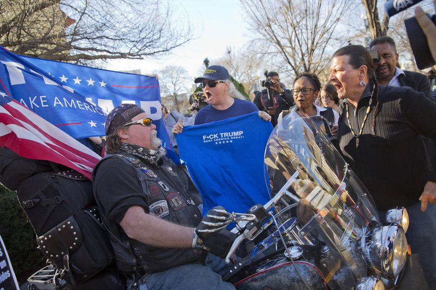 A Trump supporter, left, is surrounded by demonstrators during a rally in downtown Washington, Monday, Feb. 20, 2017. The DC rally is one of several "Not My President's Day" protests planned across the country to mark the President's Day holiday. Protesters are criticizing Trump's immigration policies, among other things. (AP Photo/Pablo Martinez Monsivais)