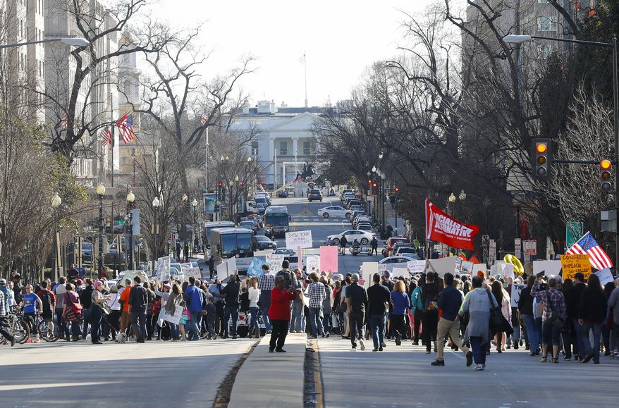 Demonstrators march downtown toward the White House during a rally in Washington, Monday, Feb. 20, 2017. The DC rally is one of several "Not My President's Day" protests planned across the country to mark the President's Day holiday. Protesters are criticizing Trump's immigration policies, among other things. (AP Photo/Pablo Martinez Monsivais)