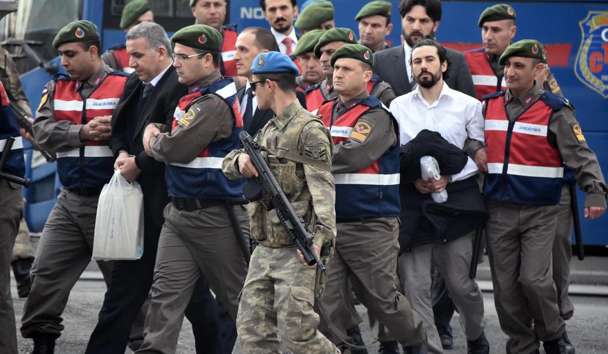 Paramilitary police escort defendants as a trial opened in Mugla, southern Turkey, Monday, Feb. 20, 2017. The trial for 47 people charged with attempting to kill President Recep Tayyip Erdogan on the night of the failed coup, while he was vacationing with his family. The suspects - 37 of them former military personnel - face possible life sentences on charges that include attempted assassination, overthrow of the constitutional order and other crimes against the state during the July 15 coup attempt ( DHA-Depo Photos via AP)