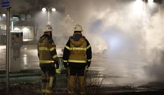 Fire fighters in the suburb Rinkeby outside Stockholm,  Monday Feb. 20, 2017.  Swedish police on Tuesday were investigating a riot that broke out overnight in a predominantly immigrant suburb in Stockholm after officers arrested a suspect on drug charges. The clashes started late Monday when a police car arrested a suspect and people started throwing stones at them. (Christine Olsson / TT via AP)