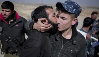 A civilian kisses a federal police officer after escaping Islamic State territory in the town of Abu Saif, Tuesday, Feb. 21, 2017.  Iraqi forces advanced into the southern outskirts of Mosul in a push to drive Islamic State militants from the city&#x27;s western half, as the visiting U.S. defense secretary met with officials to discuss the fight against the extremists.(AP Photo/Bram Janssen)