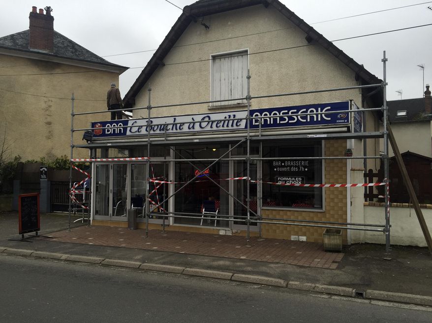A man stands on the scaffolding of the local cafe "Le Bouche à Oreille" restaurant Monday, Feb. 20, 2017 in Bourges, central France. The Michelin Guide has accidentally awarded one of its coveted stars to the cafe that shares its name with a gastronomic restaurant 150 kilometers (93 miles) away. (AP Photo/Milos Krivokapic)