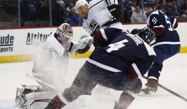Los Angeles Kings center Trevor Lewis, back center, scores a goal past Colorado Avalanche goalie Calvin Pickard, back left, as Colorado Avalanche defensemen Tyson Barrie, front, and Fedor Tyutin, of Russia, cover in the second period of an NHL hockey game, Tuesday, Feb. 21, 2017, in Denver. (AP Photo/David Zalubowski)