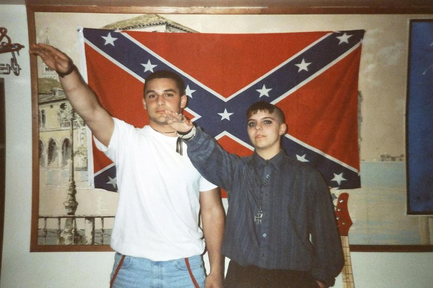 This undated photo provided by Christian Picciolini shows him at left with Shannon Martinez giving Nazi salutes while both were affiliated with racist skinhead organizations as young people decades ago. Picciolini went on to begin Life After Hate, a nonprofit that works to get people out of extremist groups, and Martinez volunteers by talking to people in an online forum sponsored by the organization. (Alex Picciolini/Courtesy of Christian Picciolini via AP)