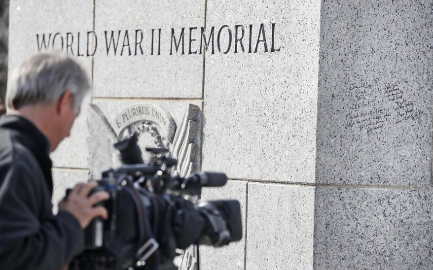 A news videographer works to tape the graffiti on the World War II Memorial, Tuesday, Feb. 21, 2017, in Washington. U.S. Park Police spokeswoman Sgt. Anna Rose said that the messages written in permanent marker were discovered over the holiday weekend at the Lincoln Memorial, the Washington Monument and the World War II Memorial. (AP Photo/Alex Brandon)
