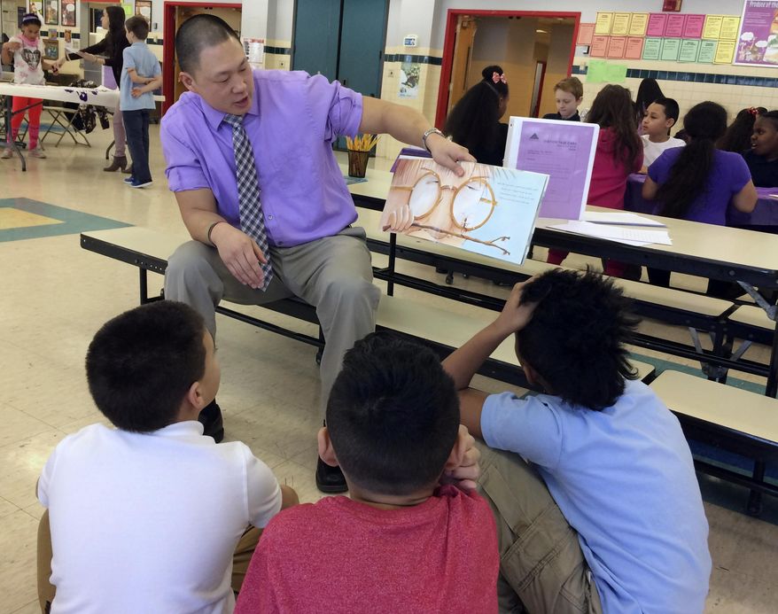 In this Feb. 14, 2017 photo, teacher Craig Muzzy reads a story about peer pressure to students at the Chamberlain Elementary School in New Britain, Conn., as part of the Love Wins program's Friendship Day. The emotional-learning program is designed to deal with the problem of social isolation and teach students about empathy. (AP Photo/Pat Eaton-Robb)