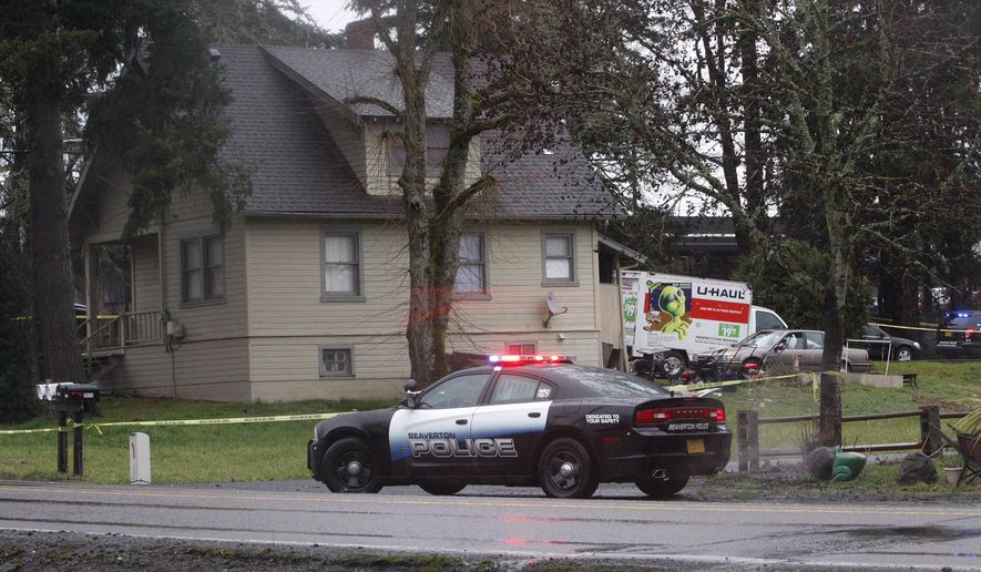 Beaverton, Oregon police close streets near Southwest 170th Avenue and Merlo Road after two officers shot and killed an armed man on a roof Tuesday, Feb. 21, 2017, a spokesman said. Officer Mike Rowe said a man armed with a gun climbed onto a home and aimed his weapon at people inside the home and on the street. The investigation is ongoing. (Tony Hernandez/The Oregonian via AP)