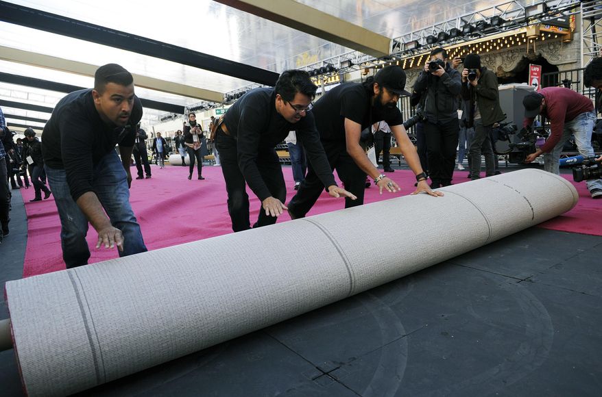 Crew workers roll out the red carpet for the 89th Academy Awards in front of the Dolby Theatre on Wednesday, Feb. 22, 2017, in Los Angeles. The 89th Academy Awards will be held on Sunday. (Photo by Chris Pizzello/Invision/AP)