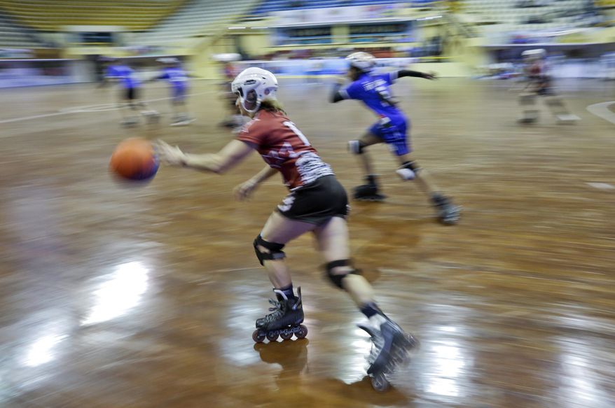 In this Tuesday, Feb. 21, 2017 photo, Aija Apsipe, left, of Latvia dribbles the ball during the 4th Roll Ball World Cup quarterfinal match against India at Shaheed Sohrawardi Indoor Stadium in Dhaka, Bangladesh. Bangladesh hosted the championship for an unusual sport, roll ball, where players on roller skates dribble and pass a basketball-sized ball that they try to throw into a small soccer-type goal. About 750 players from 40 countries around the world took part. Top honors, both for men and women, went to India, where the sport was invented. (AP Photo/A.M. Ahad)