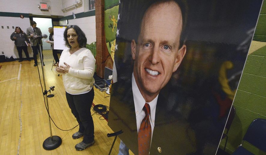 Anna Washick, of Thornhurst, Pa., tells her story regarding health care next to a large photograph of Sen. Pat Toomey, R-Pa., at the United Neighborhood Center in Scranton, Pa., Tuesday, Feb. 21, 2017. Toomey was invited to speak at the town hall, but did not attend. (Butch Comegys/The Times & Tribune via AP)