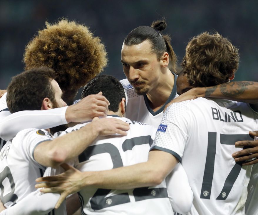 Manchester United's Henrikh Mkhitaryan, center back to camera, celebrates scoring the opening goal with Zlatan Ibrahimovic, 2nd right, and other teammates during a Europa League round of 32 second leg soccer match between Saint Etienne and Manchester United at Geoffroy Guichard stadium in Saint Etienne, France, Wednesday, Feb. 22, 2017. (AP Photo/Laurent Cipriani)