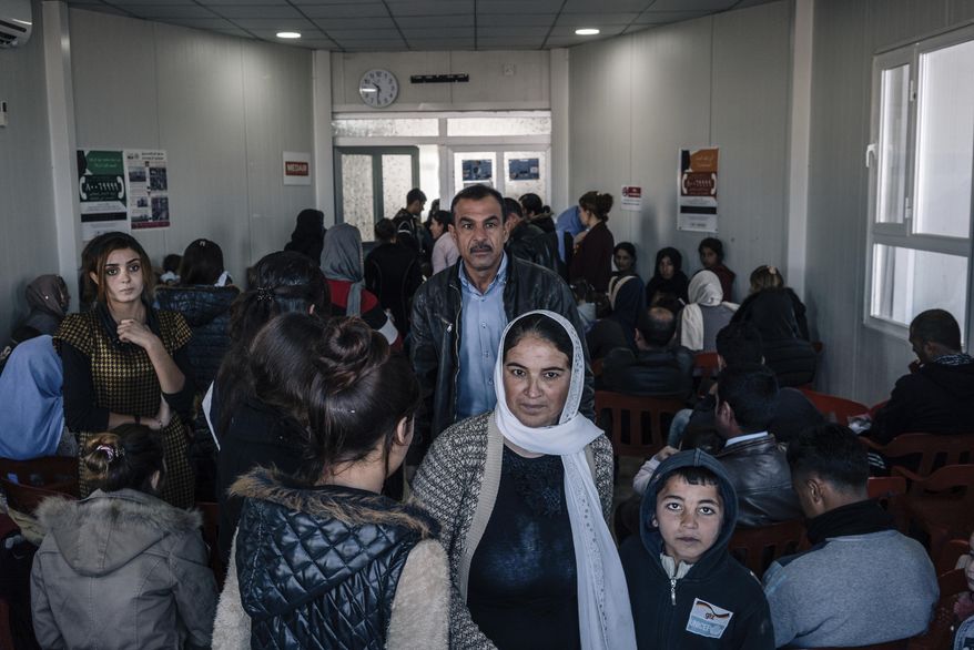 In this Jan. 12, 2017 photo, Yazidis fill a crowded waiting room at a clinic inside the Sharya camp for civilians displaced by war in Iraq. A new psychological trauma institute is being established at the university of Dohuk in Iraq, the first in the entire region. The program will train local mental health professionals to treat Islamic State victims, including thousands of Yazidi women and children. It will open at the end of the month. (AP Photo/Alice Martins)