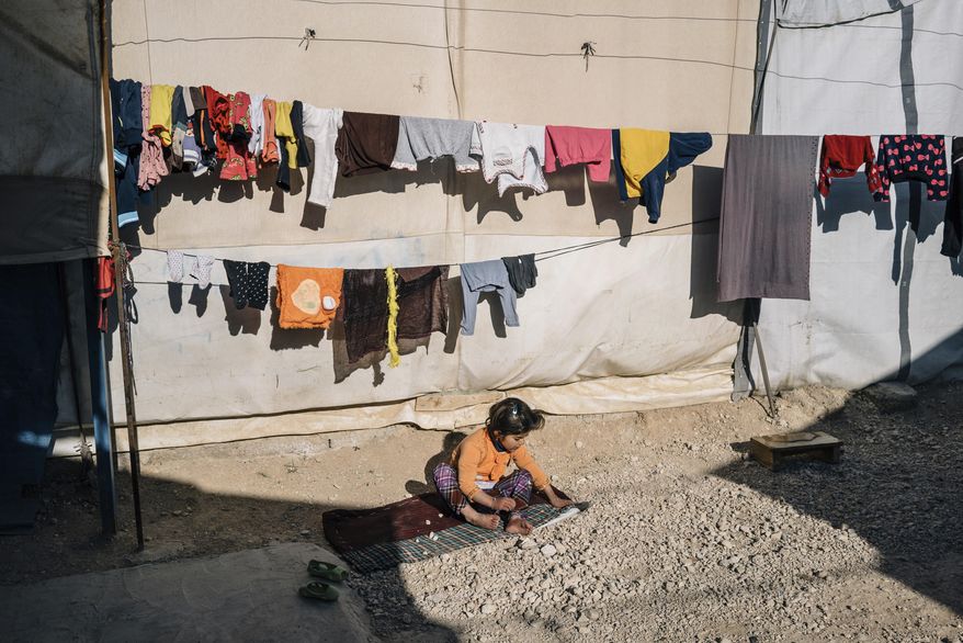 In this Jan. 12, 2017 photo, a girl plays at the Sharya camp for civilians displaced by war in Iraq. A new psychological trauma institute is being established at the university of Dohuk in Iraq, the first in the entire region. The program will train local mental health professionals to treat Islamic State victims, including thousands of Yazidi women and children. It will open at the end of the month. (AP Photo/Alice Martins)