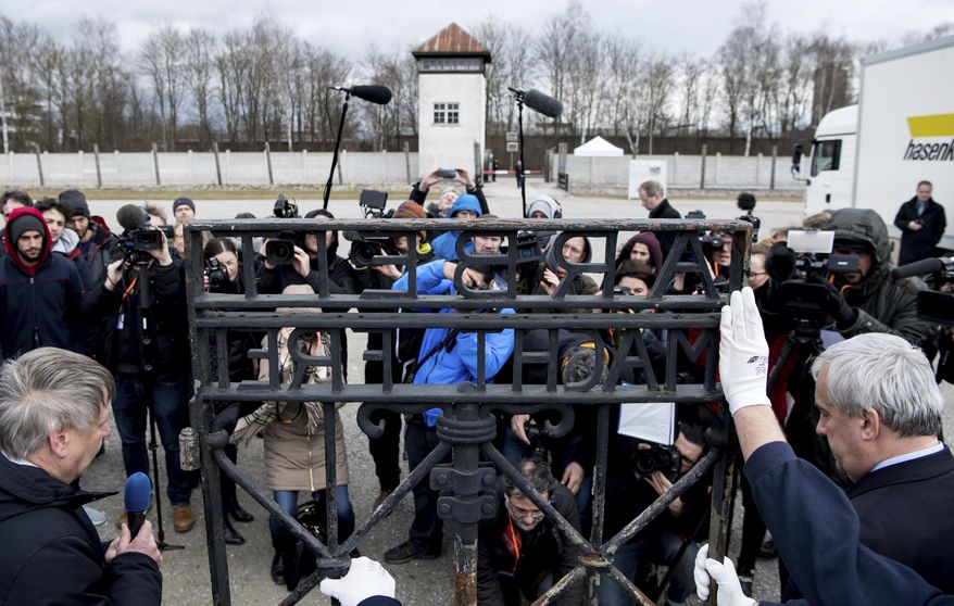 Journalists film and photograph the historic gate of the memorial site of the memorial of the former Nazi concentration camp in Dachau, Germany, Wednesday, Feb. 22, 2017. The gate was stolen in 2014 and reappeared in November 2016 near the city of Bergen in Norway. (Sven Hoppe/dpa via AP)