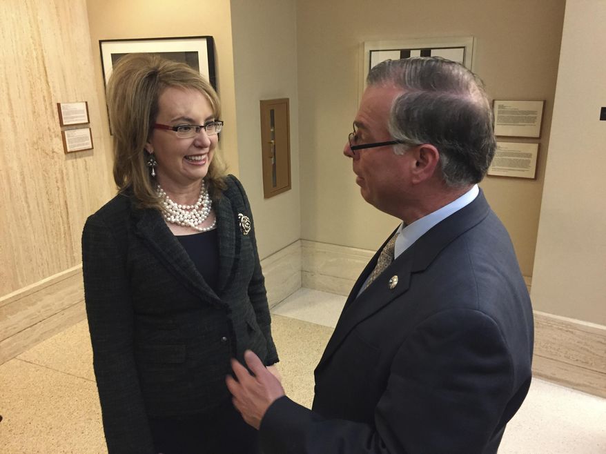 Former U.S. Congresswoman and mass shooting survivor Gabrielle Giffords, left, talks with Democratic New Mexico Sen. Daniel Ivey-Soto in Santa Fe, N.M., on Wednesday, Feb. 22, 2017. Giffords and her national gun-safety advocacy group Americans for Responsible Solutions are trying to build support for bills that would expand background checks on private firearms sales in New Mexico and remove guns from domestic violence situations where a restraining order has bee issued. (AP Photo/Morgan Lee)