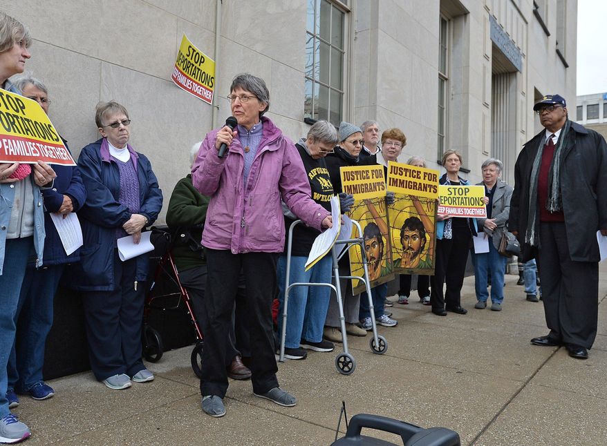 Benedictine Sister Anne McCarthy leads a "Build Bridges Not Walls'' immigration vigil at Perry Square near the U.S. District Courthouse in Erie, Pa., Wednesday, Feb. 22, 2017. About 60 attended the vigil, where speakers denounced President Donald Trump's temporary immigration and refugee bans. (Christopher Millette