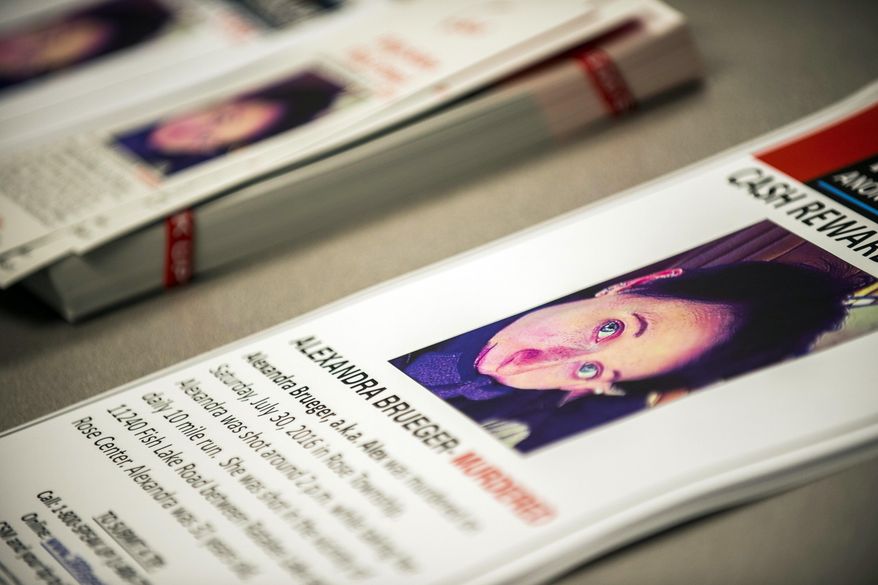 Posters featuring the face of Alexandra Brueger rest in a pile as family members speak out for the first time during a Crime Stoppers press conference Tuesday, Feb. 21, 2017, at the Rose Township Hall, in Mich., seeking any information or answers for the death of Brueger, who was fatally shot four times in the back during a July 31 afternoon jog. (Jake May /The Flint Journal-MLive.com via AP)